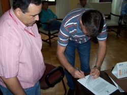 Luis Hamilton Pereira Jnior (E, presidente da Comisso Permanente de Licitaes) observa Glauco Gioda Marques no momento da assinatura do contrato
