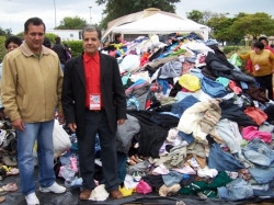 Secretrio Sandro (E) e presidente da Ucaci, Roberto Martinez, posam ao lado dos donativos