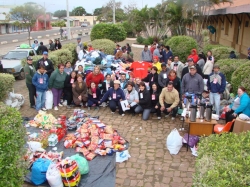 Equipes de trabalho da Ao Social e da UCACI posam juntas ao montante de roupas e alimentos arrecadados