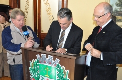 Arnaldo Dutra, observado pelo prefeito Gil, assina documento que prev investimentos no municpio
