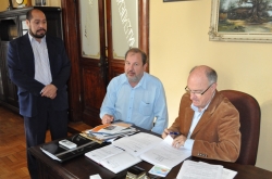 Gil (D) l os documentos sobre as emendas ao lado do deputado Stdile. Em p, o vice-prefeito Celso