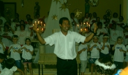 Coral da Maior Idade se apresenta na Festa de Natal do Santa Teresa de Jesus acompanhado por alunos do colgio. Em primeiro plano, o maestro Benjamim da Silva Filho