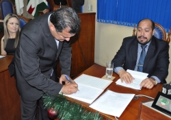 Prefeito Celso observa o vereador Sandro assinar o livro de posse da nova mesa diretora